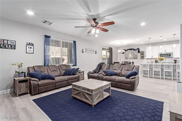 living room with ceiling fan and light hardwood / wood-style floors