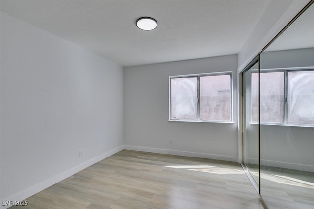 unfurnished room featuring light wood-type flooring and a wealth of natural light