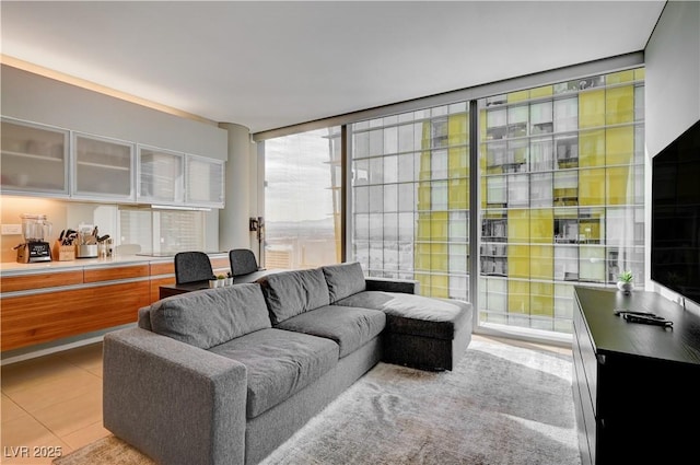 living room with light tile patterned floors and a wall of windows