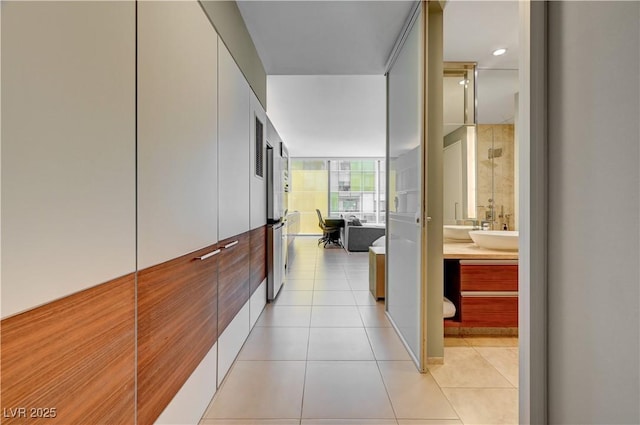 hall with sink and light tile patterned flooring