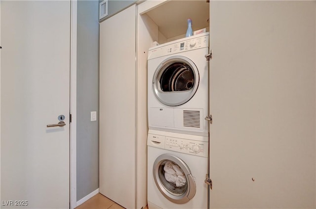 clothes washing area with stacked washer / dryer