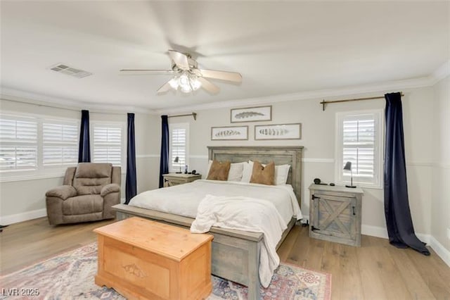 bedroom featuring ornamental molding, light hardwood / wood-style floors, and multiple windows