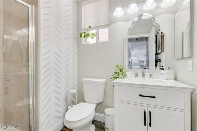 bathroom with toilet, a shower with door, and vanity