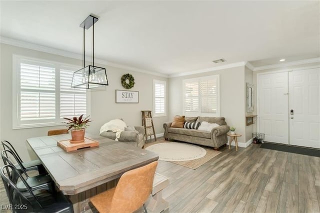 dining space with crown molding and hardwood / wood-style floors