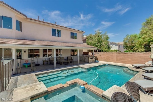 view of pool with an in ground hot tub, exterior bar, and a patio