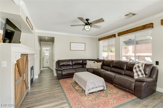 living room featuring hardwood / wood-style floors, ceiling fan, and crown molding