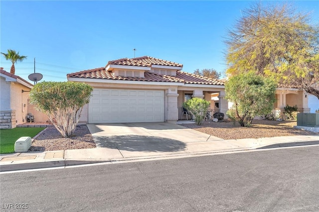 mediterranean / spanish-style home with concrete driveway, a tiled roof, an attached garage, and stucco siding