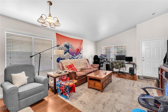 living area with a chandelier, vaulted ceiling, and wood finished floors