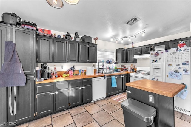 kitchen with white appliances, visible vents, under cabinet range hood, and wood counters