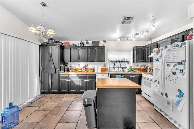 kitchen featuring visible vents, a sink, wood counters, white appliances, and a chandelier