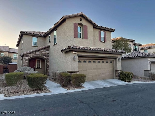 mediterranean / spanish house with an attached garage, stone siding, driveway, and stucco siding