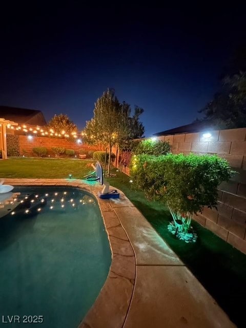 pool at night with a yard