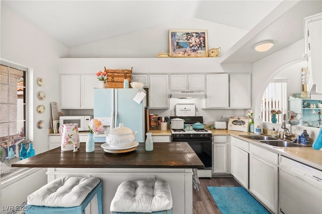 kitchen with white appliances, white cabinetry, sink, and lofted ceiling