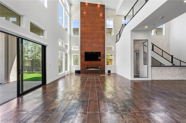 unfurnished living room featuring a high ceiling and a fireplace