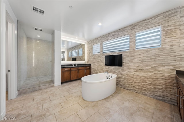 bathroom featuring tile patterned floors, vanity, and shower with separate bathtub