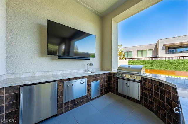 view of patio with exterior kitchen, a grill, and sink