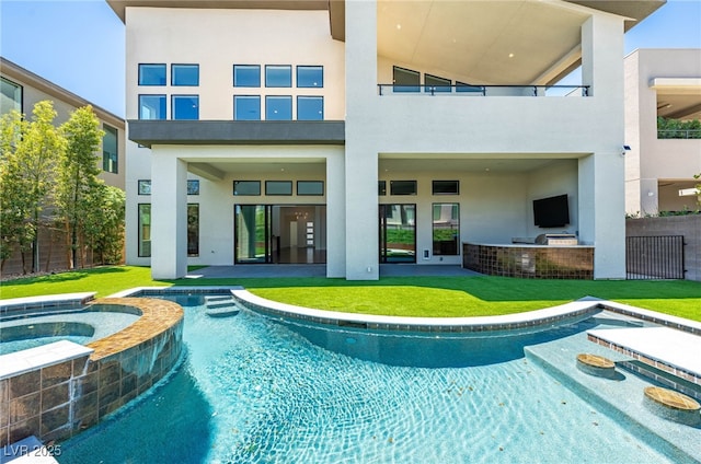 back of house with a pool with hot tub and a lawn