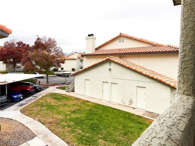 view of side of home with a carport and a lawn