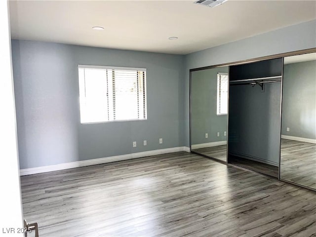 unfurnished bedroom with a closet and hardwood / wood-style flooring