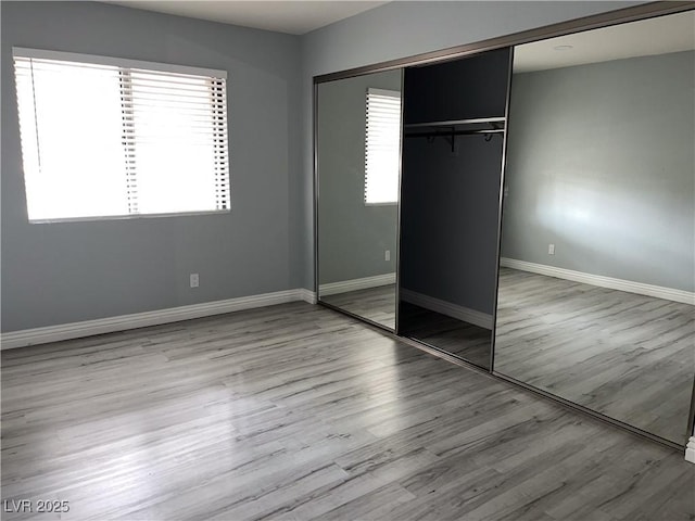 unfurnished bedroom with light hardwood / wood-style floors and a closet