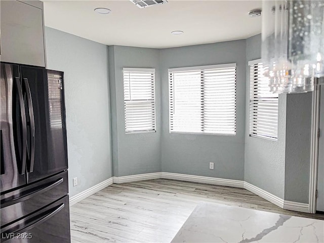 unfurnished dining area featuring light wood-type flooring