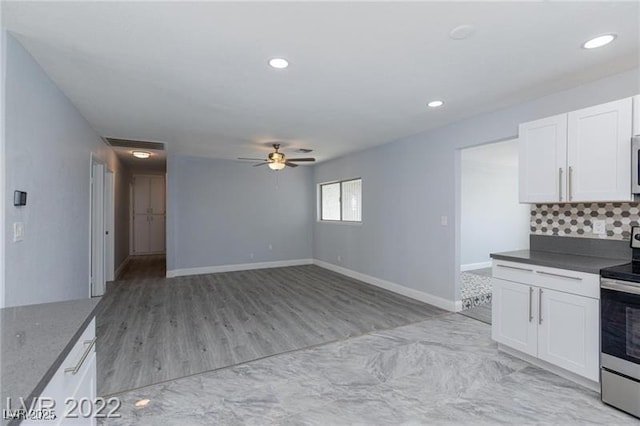 5816 W Cherokee Ave, Las Vegas, NV 89103 - kitchen featuring stainless steel range with electric stovetop, white cabinetry, light wood-type flooring, ceiling fan, and decorative backsplash