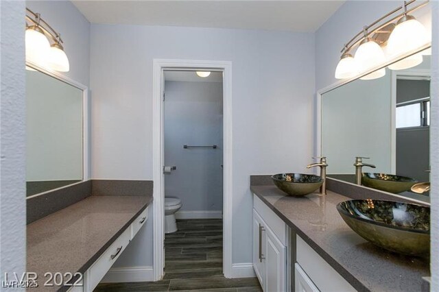 5816 W Cherokee Ave, Las Vegas, NV 89103 - bathroom featuring hardwood / wood-style floors, vanity, and toilet