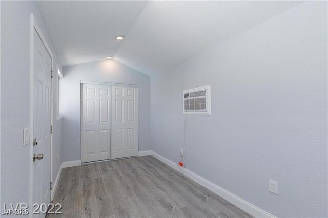 5816 W Cherokee Ave, Las Vegas, NV 89103 - unfurnished bedroom with light wood-type flooring, a closet, lofted ceiling, and an AC wall unit