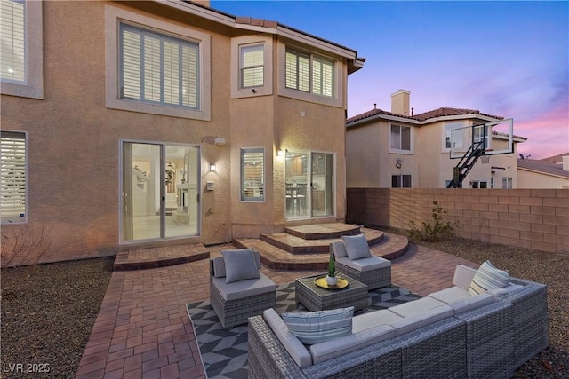 back house at dusk with a patio and an outdoor hangout area