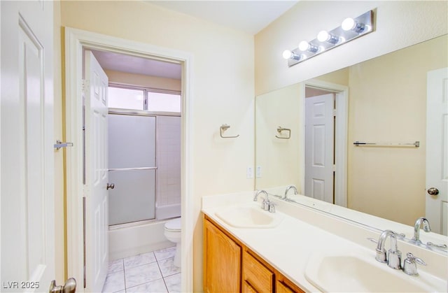 full bath featuring a sink, combined bath / shower with glass door, toilet, and double vanity