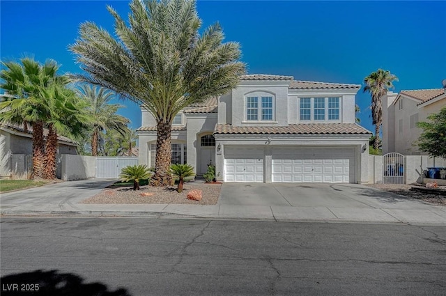 mediterranean / spanish-style home featuring a gate, driveway, a tiled roof, and stucco siding