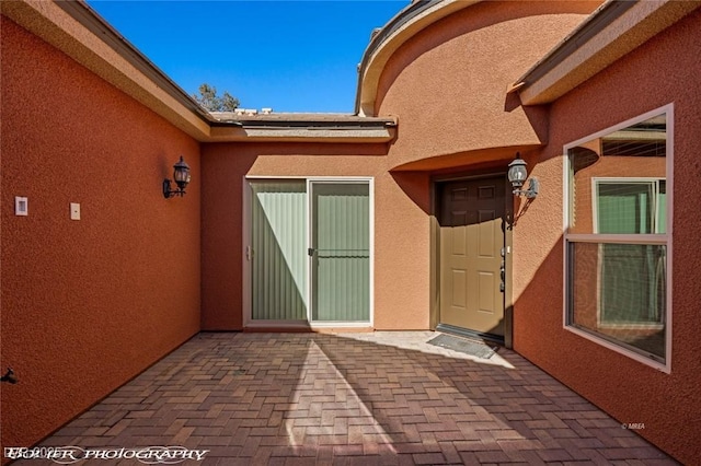 view of exterior entry with a patio area