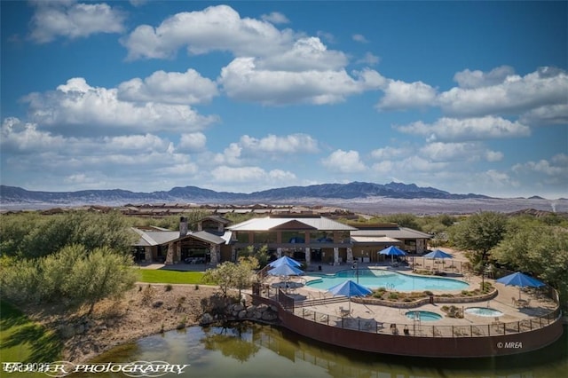 exterior space with a mountain view and a pool with hot tub