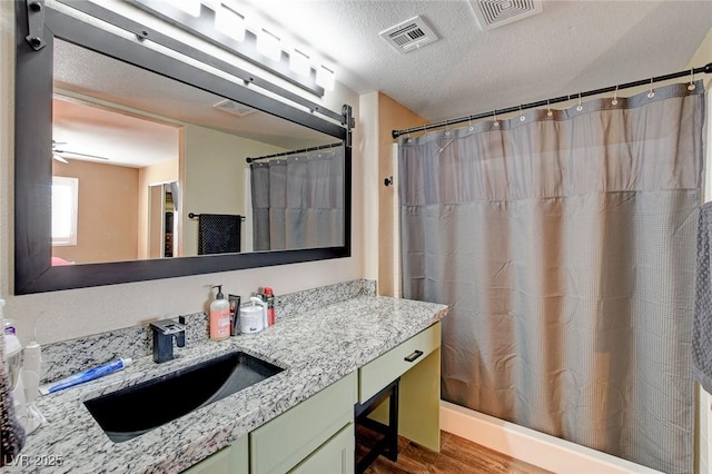 bathroom featuring a textured ceiling, vanity, wood-type flooring, and a shower with curtain