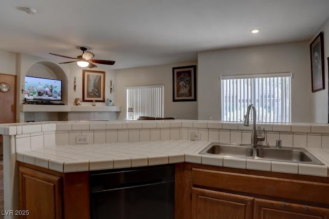 kitchen featuring sink, dishwasher, ceiling fan, kitchen peninsula, and tile counters