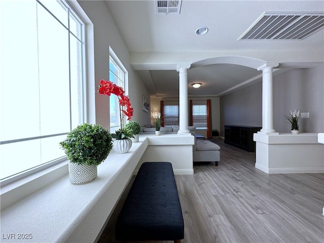 hallway with hardwood / wood-style flooring and ornate columns