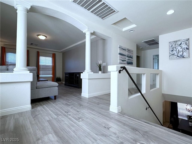 interior space with light wood-type flooring and ornate columns