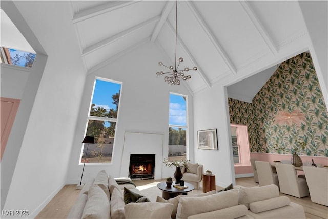 living room with a notable chandelier, high vaulted ceiling, light wood-type flooring, and beamed ceiling