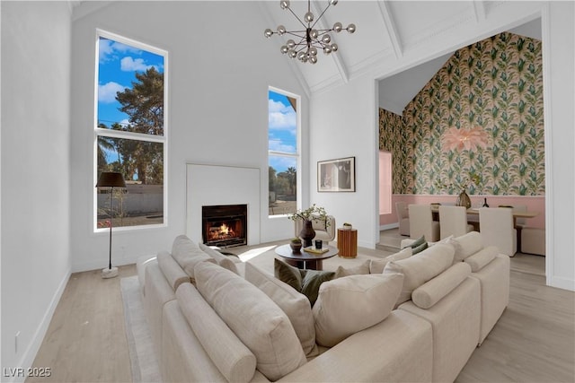 living room with light wood-type flooring, high vaulted ceiling, beamed ceiling, and a chandelier