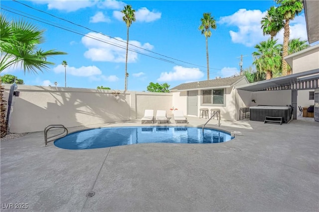 view of swimming pool with a hot tub, a patio, and an outbuilding