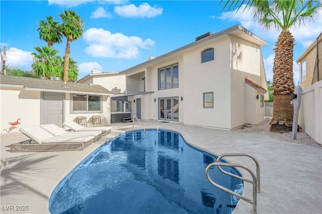 rear view of property with french doors, a patio, and exterior bar