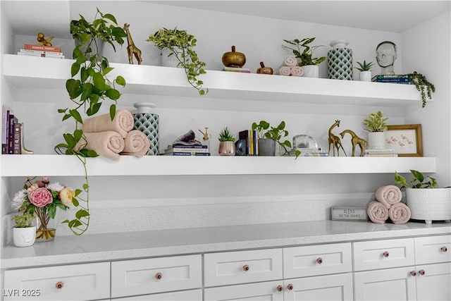 interior space featuring white cabinetry and light stone counters