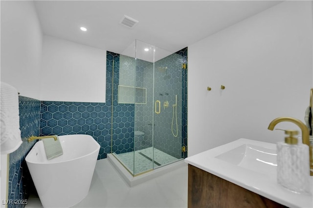 bathroom featuring plus walk in shower, tile walls, and vanity