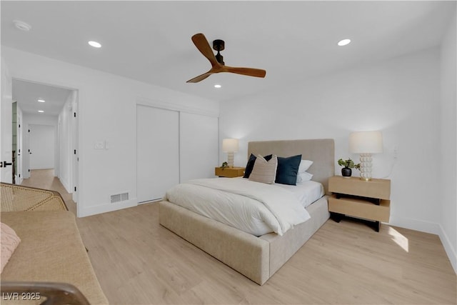 bedroom with light hardwood / wood-style floors, a closet, and ceiling fan