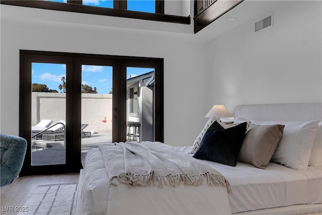 bedroom featuring french doors, access to exterior, and hardwood / wood-style flooring