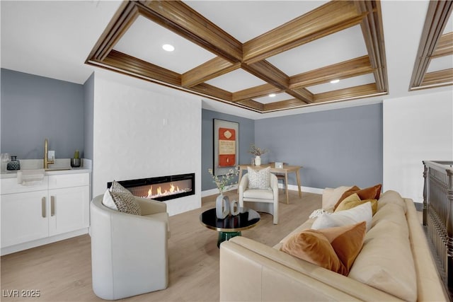 living room featuring a fireplace, light hardwood / wood-style flooring, beamed ceiling, and coffered ceiling