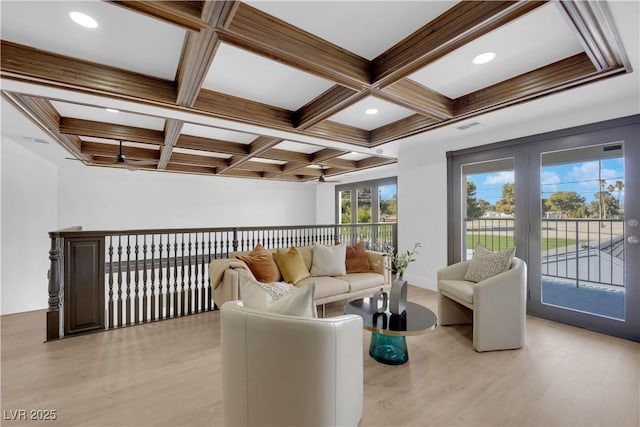 living room featuring coffered ceiling, light wood-type flooring, and beam ceiling