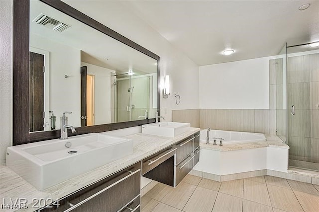 bathroom with plus walk in shower, vanity, and tile patterned flooring