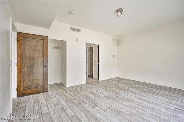 unfurnished bedroom featuring light hardwood / wood-style floors and a closet