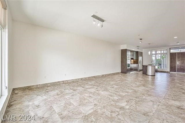 unfurnished living room featuring sink